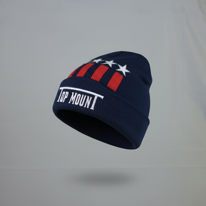 TopmounT Apparel Merica Beanie in navy blue with white embroidered logo, red stripes, and stars patriotic jacquard pattern.