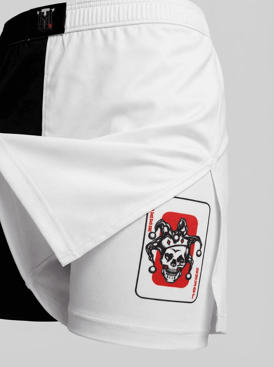 Close-up of TopmounT Youth BJJ shorts showing white dual-layer fabric and jester skull graphic on the compression liner.