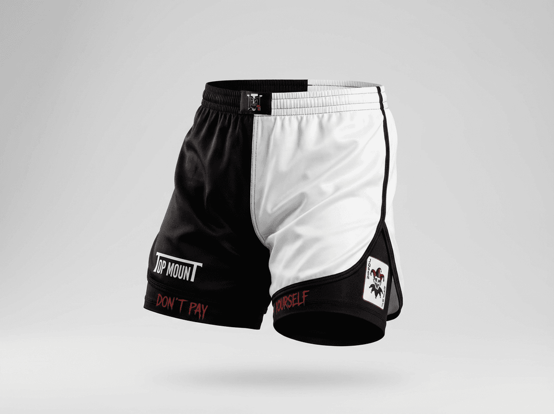 Youth BJJ black and white split grappling shorts with TopmounT logo, jester graphics, and dual-layer compression liner.