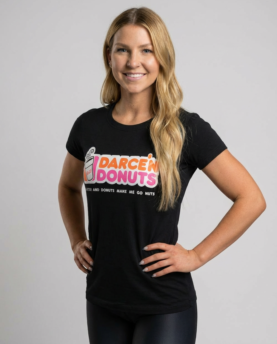 Smiling woman wearing the black Women's BJJ Tee - Darce'N Donuts Recovery Ritual graphic shirt by Top Mount Apparel.