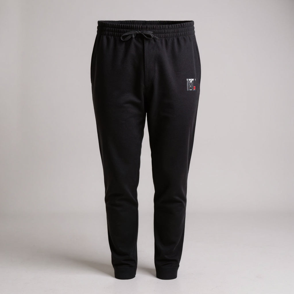 Black tapered BJJ warm up joggers featuring a drawstring waist and Top Mount logo, designed for Jiu-Jitsu training.
